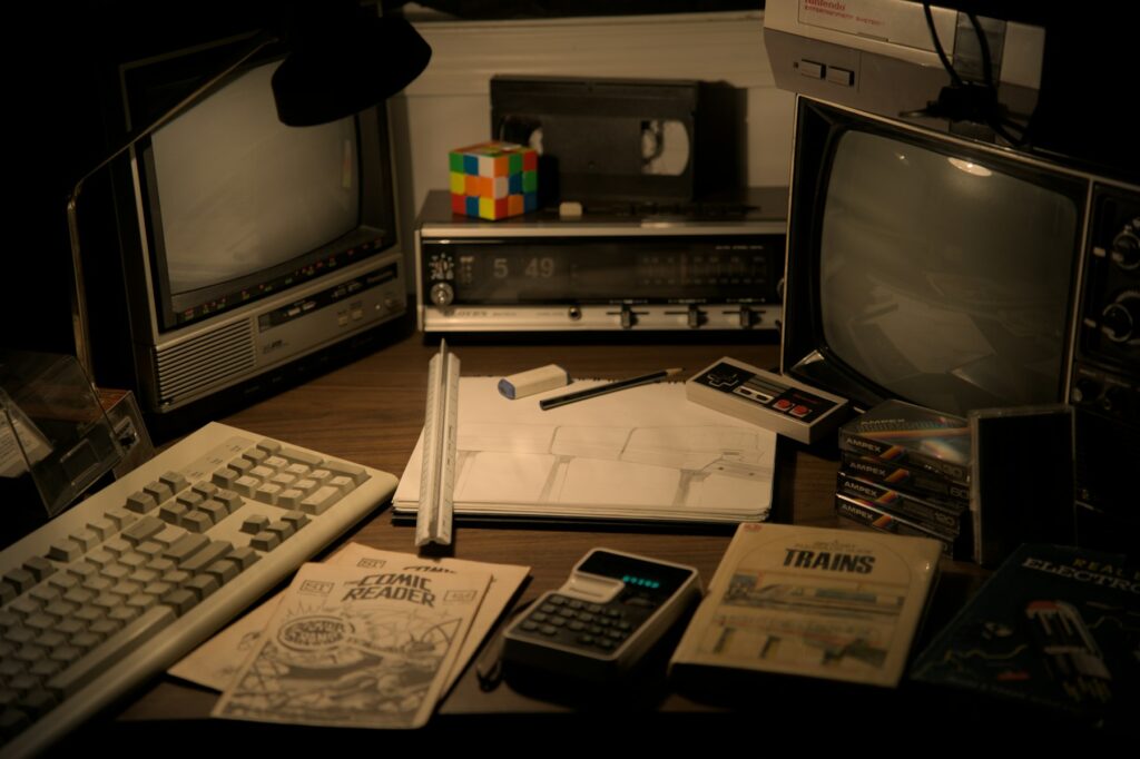 Retro electronics and desk items on a wooden surface.