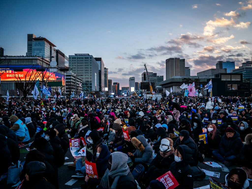 Crowd gathered in a city square at dusk