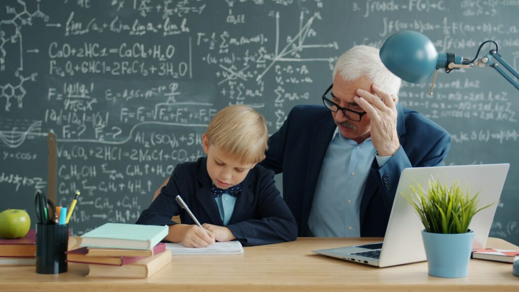 Teacher helping young student with math homework.